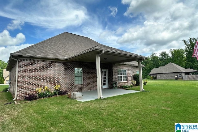 back of house with a patio, a yard, and central air condition unit