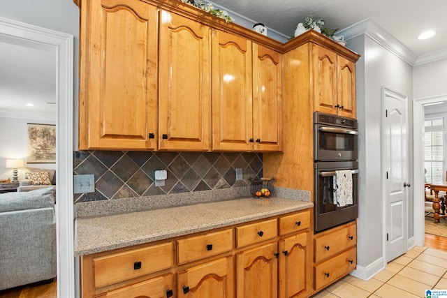 kitchen featuring double oven, light tile floors, light stone counters, tasteful backsplash, and ornamental molding