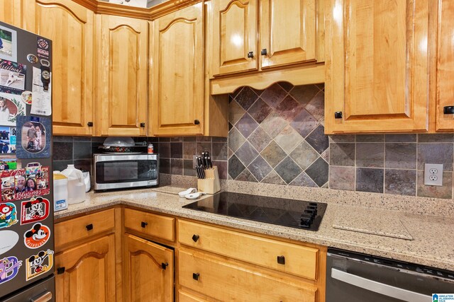 kitchen featuring light stone counters, tasteful backsplash, and black appliances