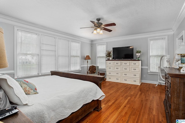bedroom with ornamental molding, ceiling fan, and hardwood / wood-style flooring