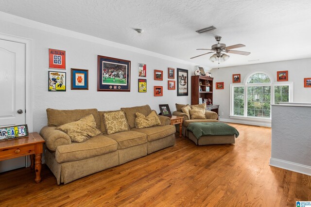 living room with hardwood / wood-style floors, a textured ceiling, and ceiling fan