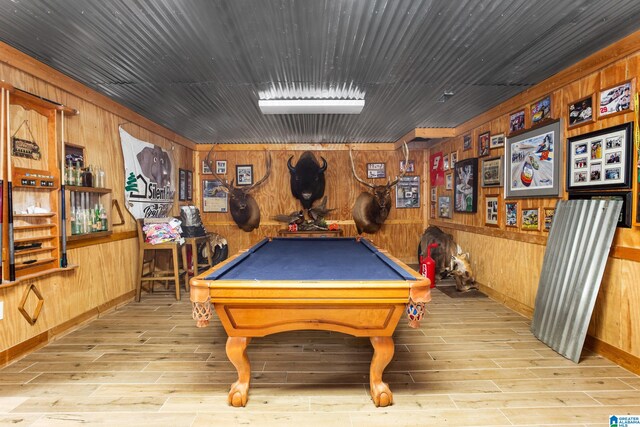 recreation room with wood walls, pool table, and light hardwood / wood-style floors