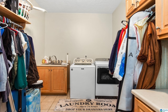 laundry room featuring cabinets, independent washer and dryer, light tile floors, and sink