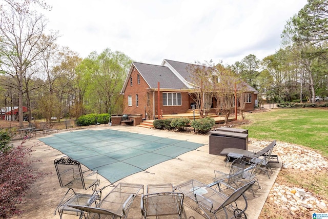 view of pool featuring a jacuzzi, a patio area, and a lawn