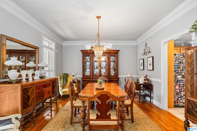 dining room with crown molding, a chandelier, and hardwood / wood-style flooring