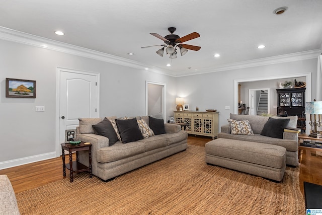 living room with ceiling fan, crown molding, and light hardwood / wood-style flooring