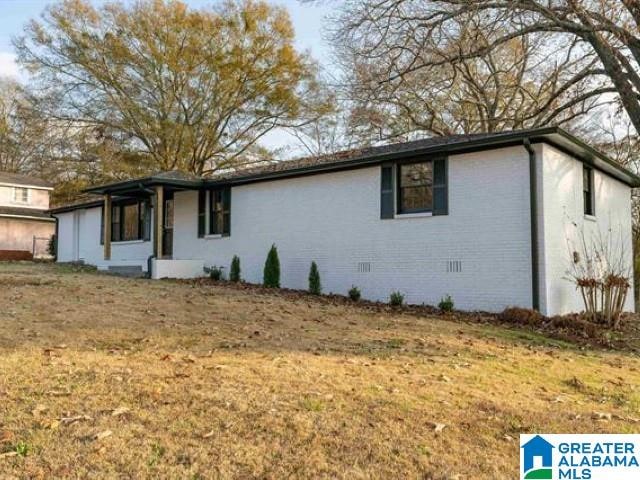 ranch-style house with crawl space, brick siding, and a front lawn