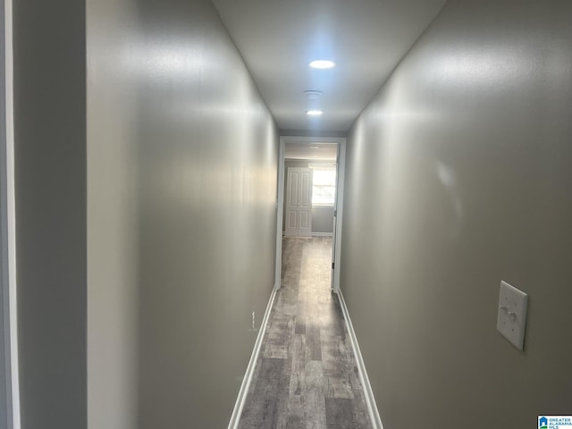 corridor featuring dark wood-style flooring and baseboards