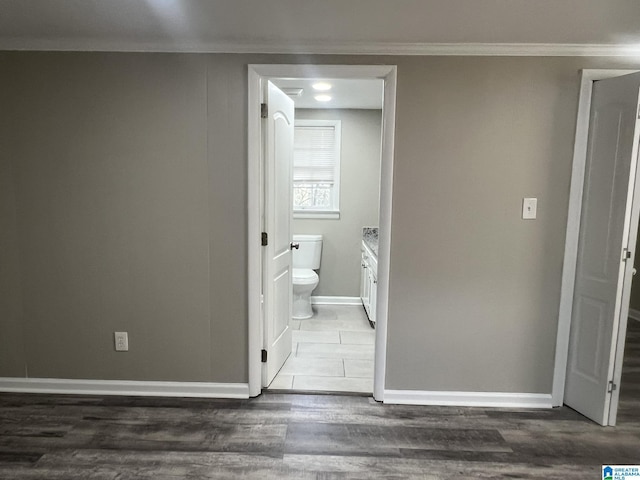 bathroom featuring crown molding, toilet, vanity, wood finished floors, and baseboards