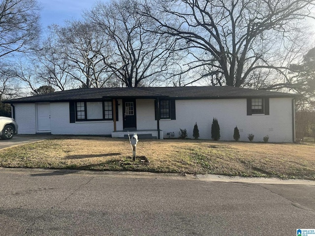 single story home with brick siding and a front yard