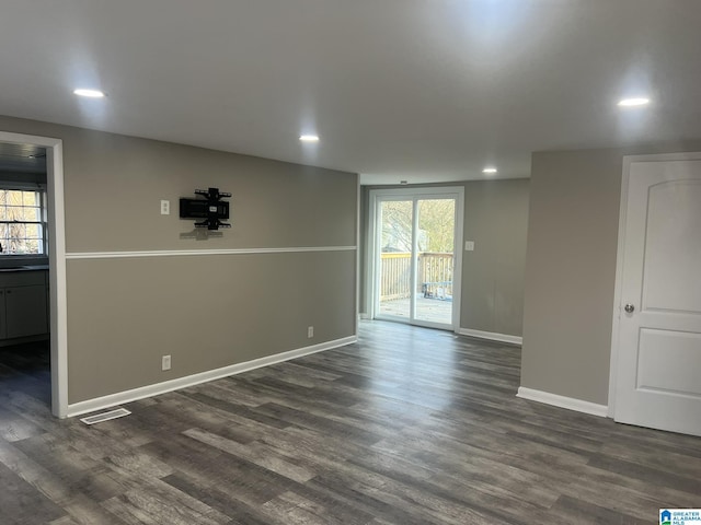 unfurnished room featuring plenty of natural light, baseboards, dark wood-type flooring, and recessed lighting