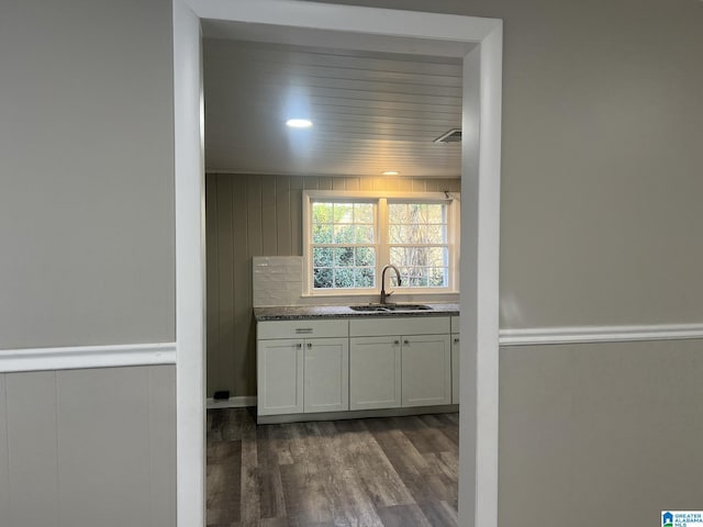 kitchen featuring dark countertops, white cabinetry, dark wood-type flooring, and a sink