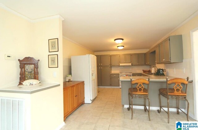 kitchen with light tile patterned floors, kitchen peninsula, backsplash, white refrigerator with ice dispenser, and a kitchen breakfast bar