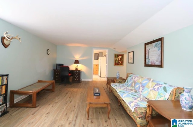 living room featuring light hardwood / wood-style flooring and vaulted ceiling