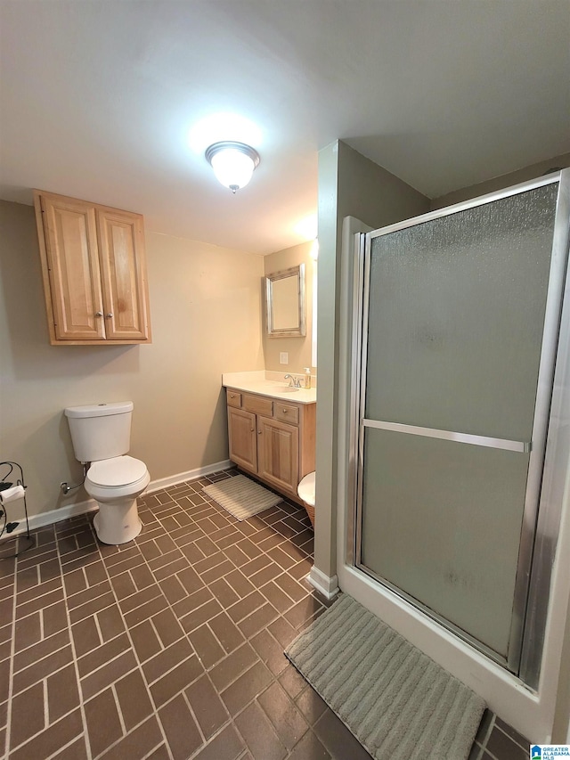 bathroom featuring vanity, a shower with shower door, and toilet