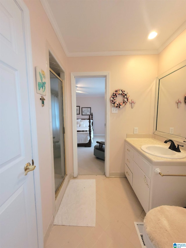 bathroom with a shower with shower door, vanity, ornamental molding, and tile patterned floors