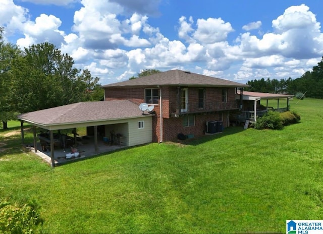 rear view of house with a lawn and central air condition unit