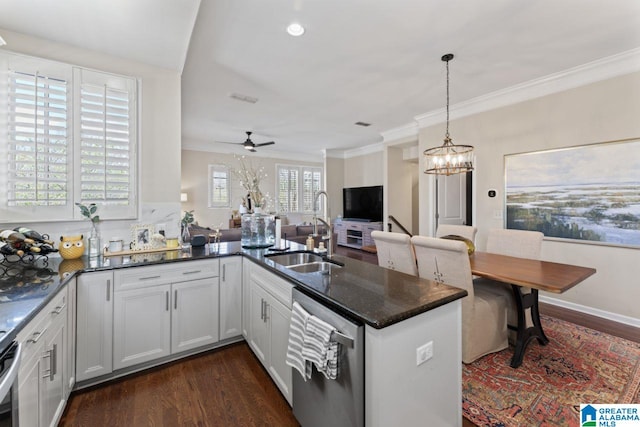 kitchen featuring pendant lighting, sink, dark hardwood / wood-style flooring, dishwasher, and ceiling fan with notable chandelier