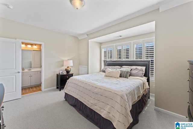 carpeted bedroom with connected bathroom and sink