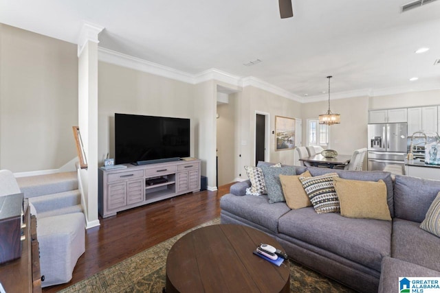 living room with dark hardwood / wood-style floors, ornamental molding, and ceiling fan with notable chandelier