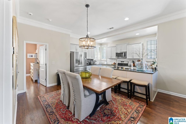 dining room with dark hardwood / wood-style flooring, an inviting chandelier, and crown molding