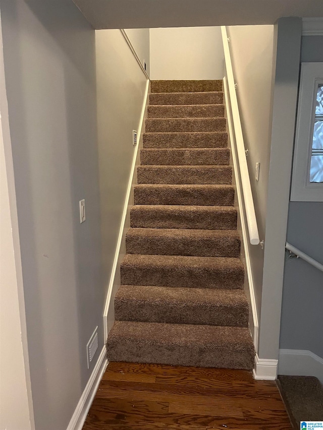 stairs with dark hardwood / wood-style floors