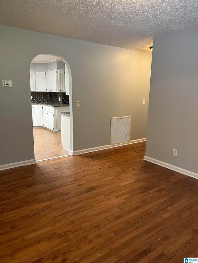 unfurnished room with light hardwood / wood-style floors and a textured ceiling