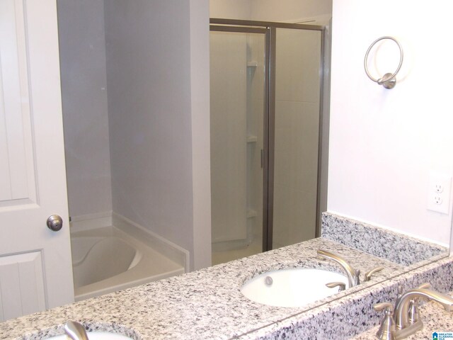 bathroom with double vanity and independent shower and bath