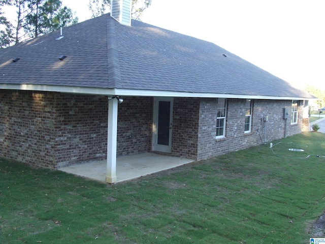 back of house featuring a patio and a lawn