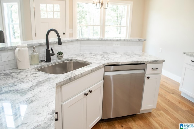 kitchen featuring white cabinets, stainless steel dishwasher, and light wood-type flooring