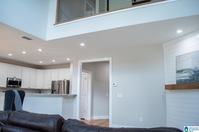 kitchen featuring white cabinets, light wood-type flooring, and stainless steel appliances