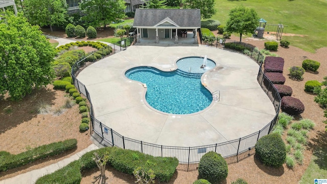 view of swimming pool featuring a hot tub and a patio area