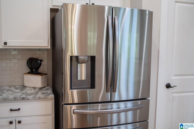 details featuring stainless steel fridge, vanity, and tasteful backsplash