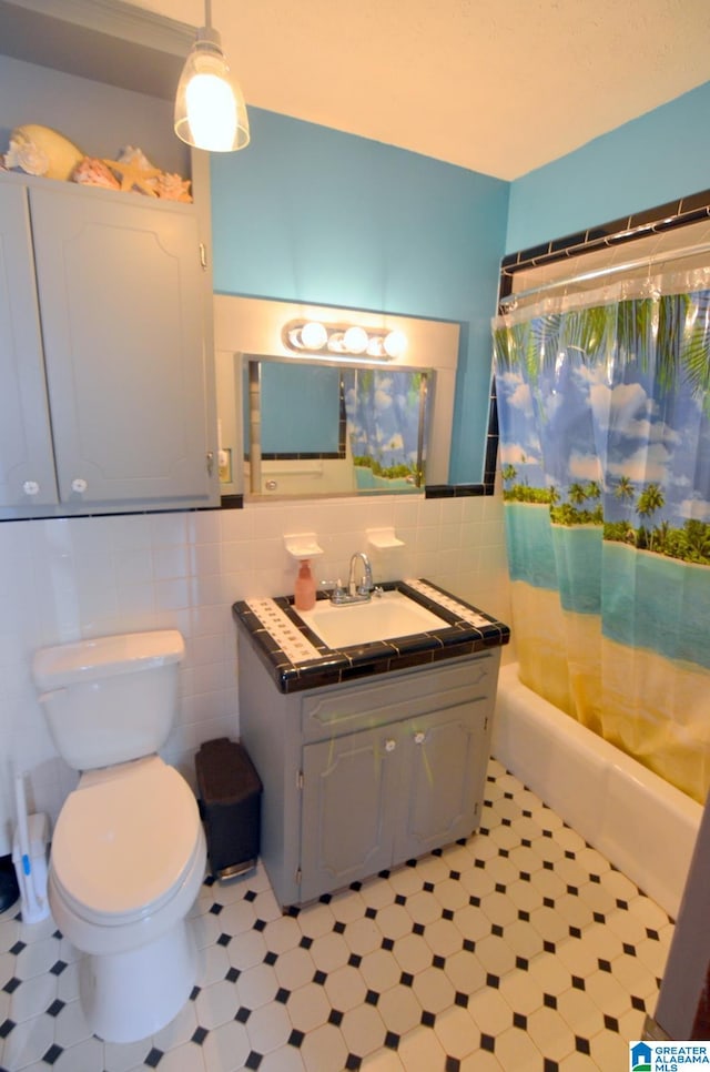 full bathroom with tile flooring, vanity with extensive cabinet space, tile walls, backsplash, and toilet