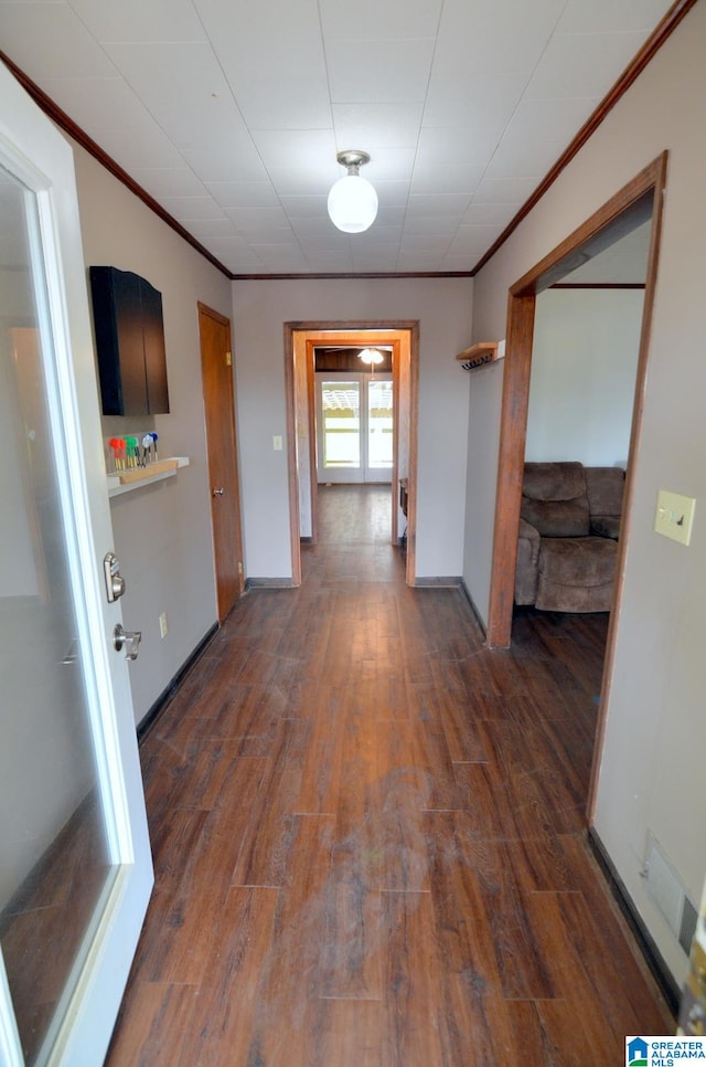 corridor with dark hardwood / wood-style flooring and ornamental molding