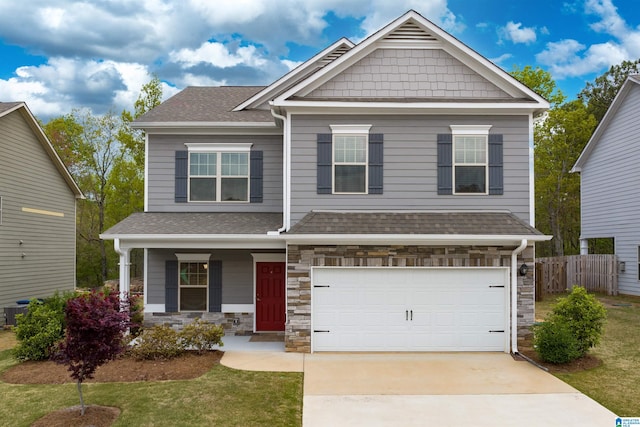 craftsman-style home with covered porch, a front yard, and a garage