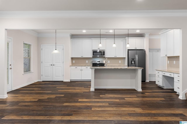 kitchen featuring dark hardwood / wood-style floors, light stone counters, white cabinets, appliances with stainless steel finishes, and decorative light fixtures