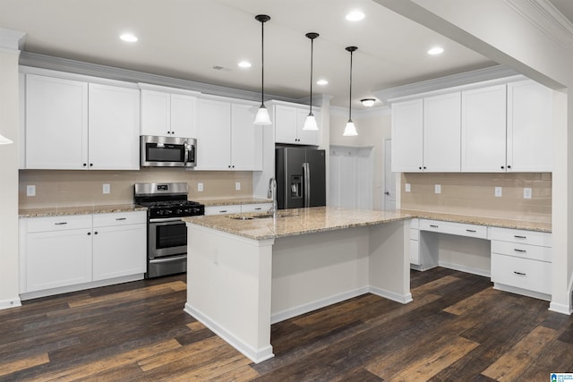 kitchen with dark wood-type flooring, appliances with stainless steel finishes, an island with sink, white cabinets, and crown molding