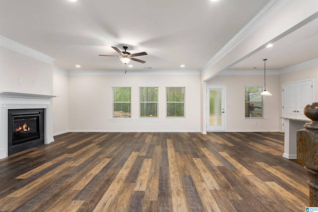 unfurnished living room featuring ornamental molding, dark hardwood / wood-style flooring, ceiling fan, and a wealth of natural light