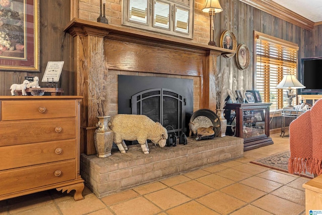tiled living room with crown molding, wood walls, and a brick fireplace