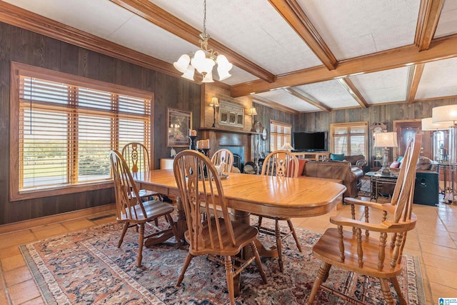 tiled dining room featuring an inviting chandelier, wood walls, and beam ceiling