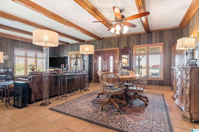 dining room featuring wooden walls, ceiling fan, and plenty of natural light