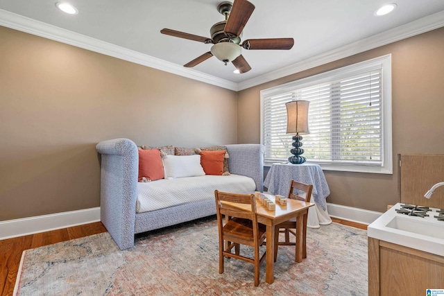 interior space with ceiling fan, crown molding, and light wood-type flooring