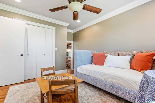bedroom featuring crown molding, a closet, ceiling fan, and light wood-type flooring