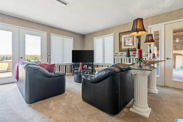 living room with french doors, a textured ceiling, and light carpet