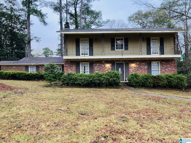 view of front of property featuring a balcony and a front yard