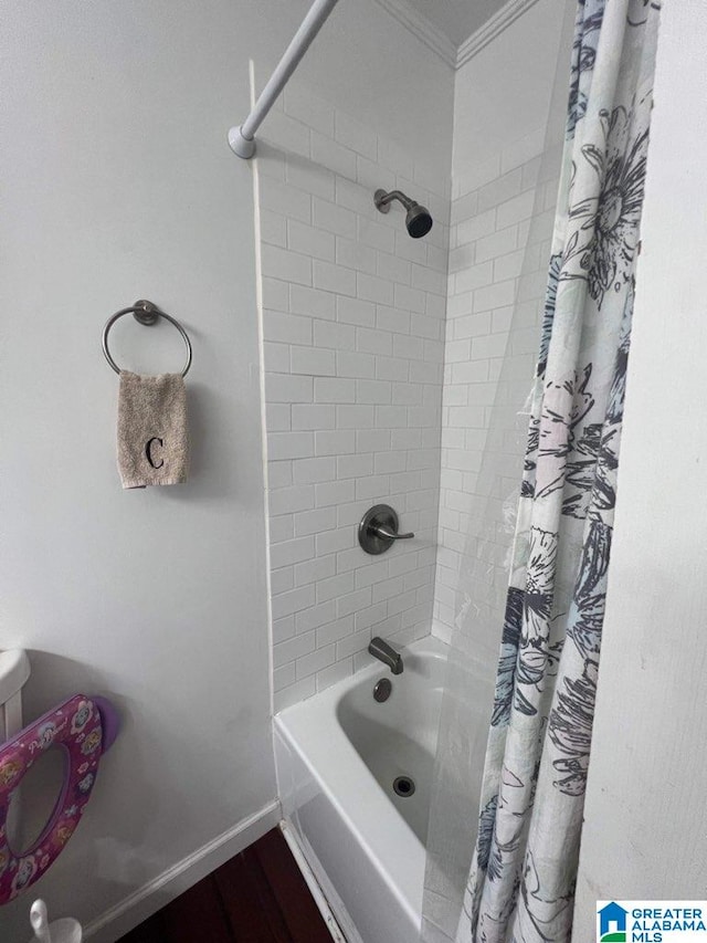 bathroom featuring ornamental molding, wood-type flooring, and shower / bathtub combination with curtain