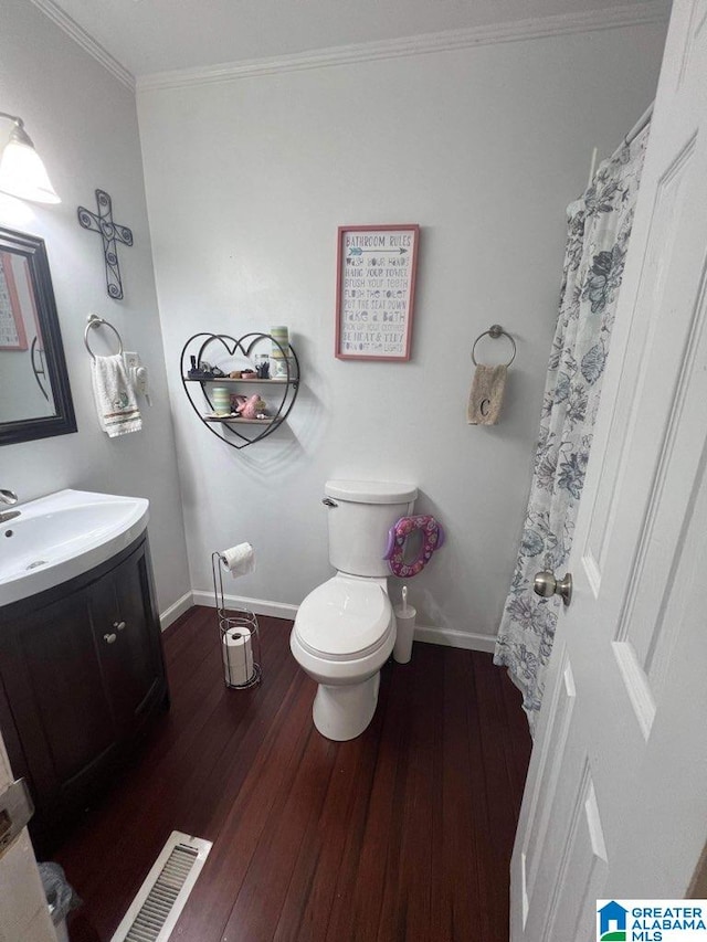 bathroom featuring ornamental molding, toilet, wood-type flooring, and vanity