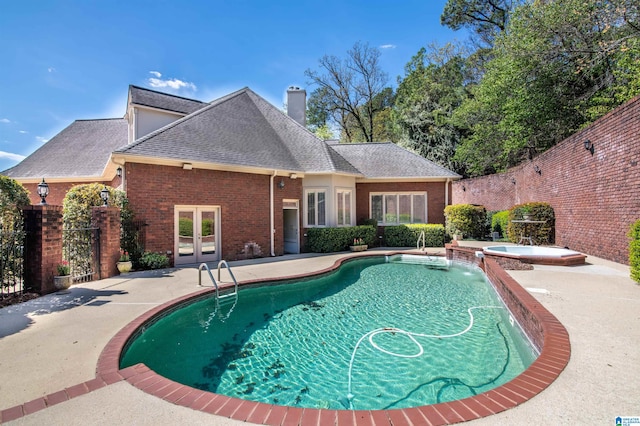 view of pool featuring a patio area, french doors, pool water feature, and an in ground hot tub