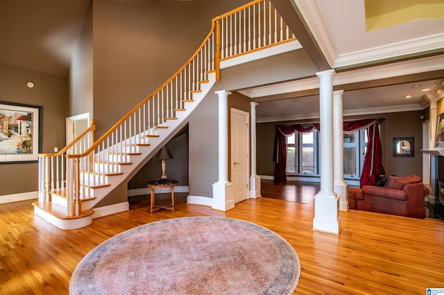 stairs featuring crown molding, a high ceiling, and hardwood / wood-style floors